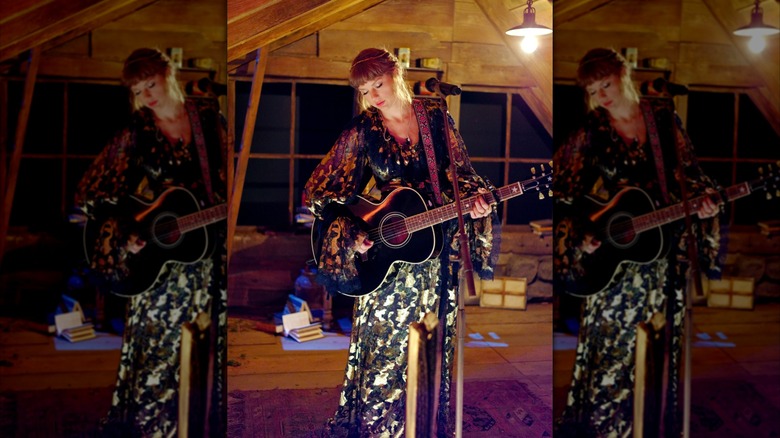 Taylor Swift on stage with a guitar