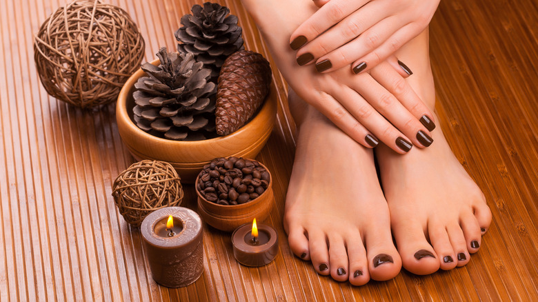 female hands and feet with brown polish