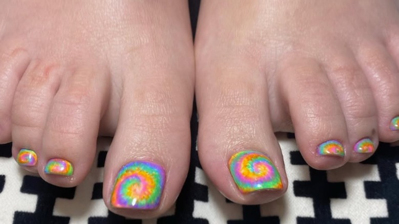 feet with tie dye nail polish design