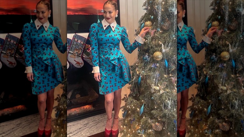 Jennifer Lopez posing by a Christmas tree