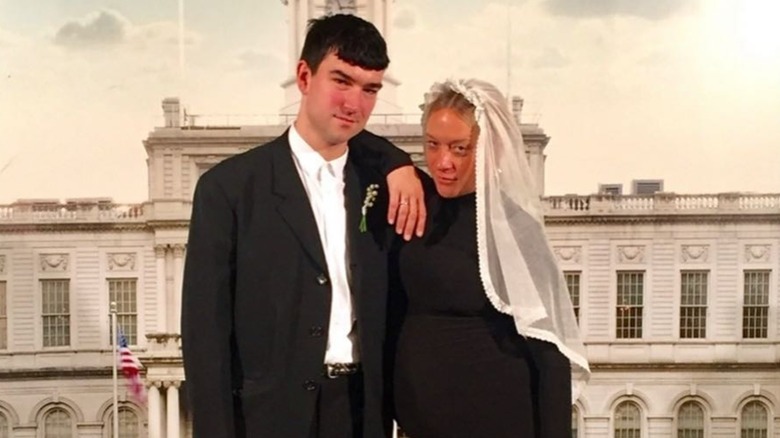 Siniša Mačković and Chloë Sevigny posing together on their wedding day in black and white outfits