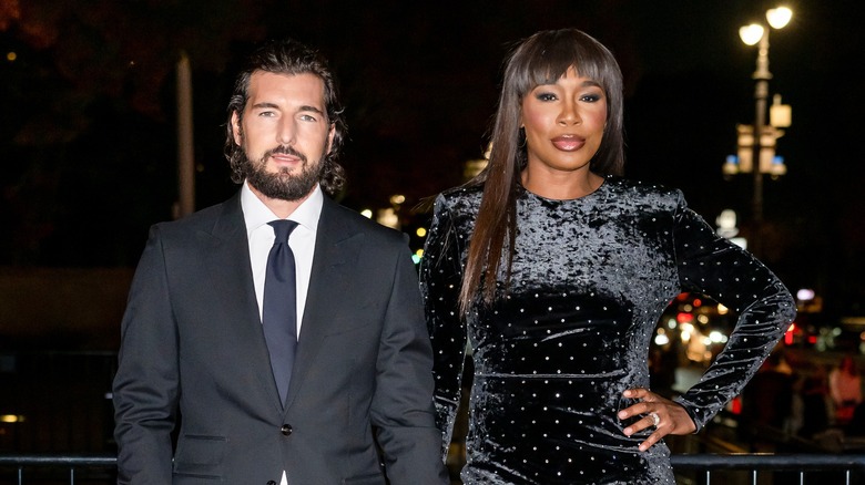 Andrea Preti holding hands with Venus Williams while posing for photos outdoors