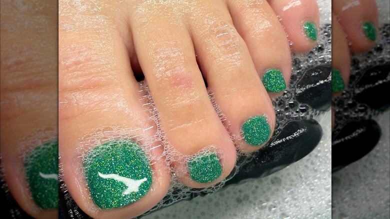 Feet with a green glitter manicure