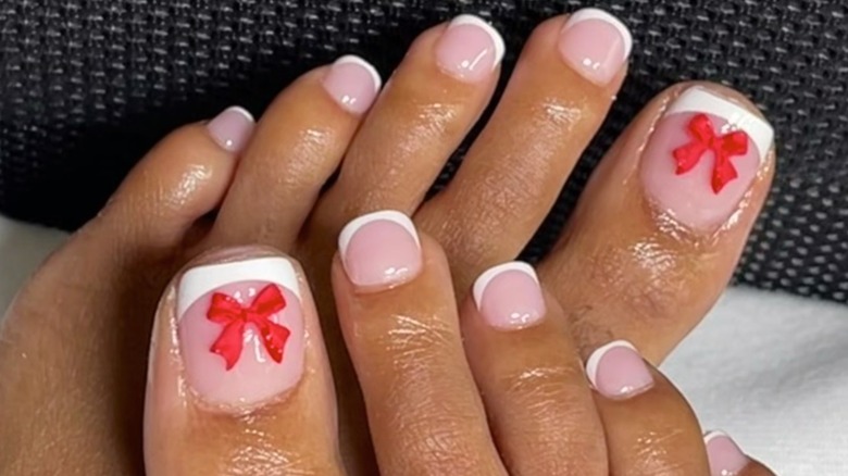 Feet with a French manicure and red bow