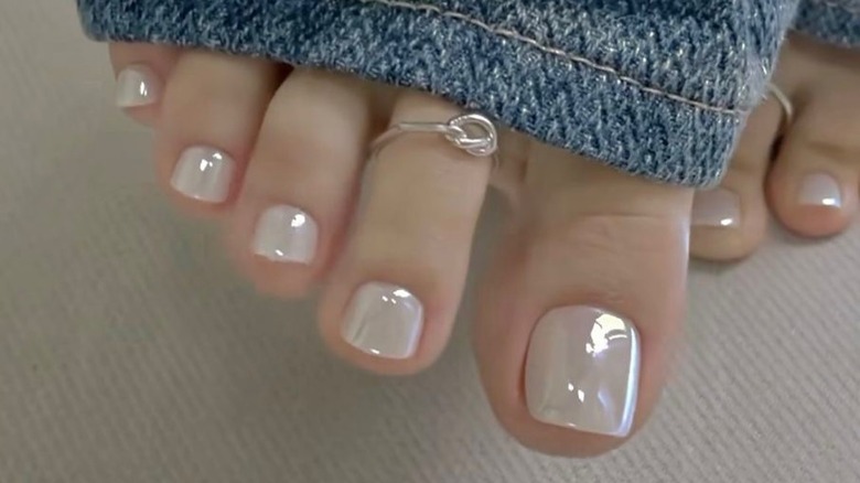 Feet with a white chrome manicure