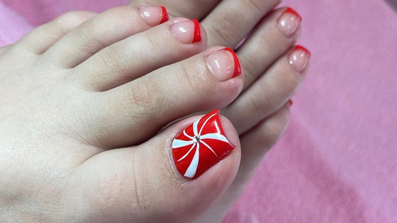 Feet with a peppermint swirl-inspired pedicure