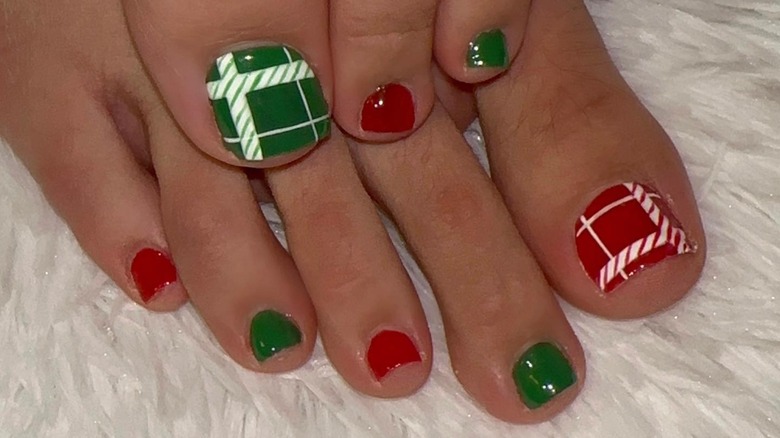 Feet with a red and green plaid manicure