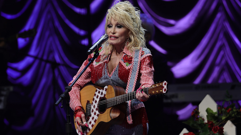 Dolly Parton playing guitar on stage