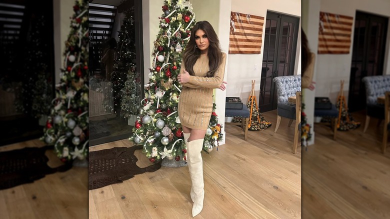 Kimberly Guilfoyle posing in front of a Christmas tree with her arms crossed