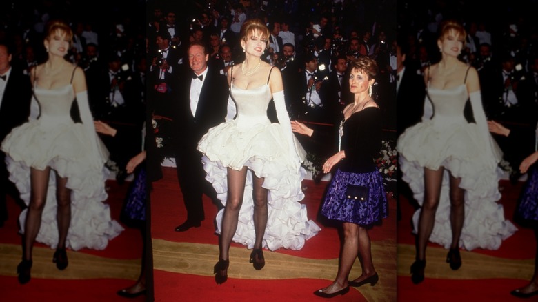 Geena Davis walks up the red carpet, wearing a white ruffled gown, at the Academy Awards in 1992