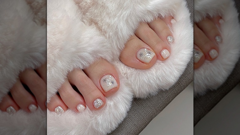 A woman with a milky pedicure and sparkles on her toes
