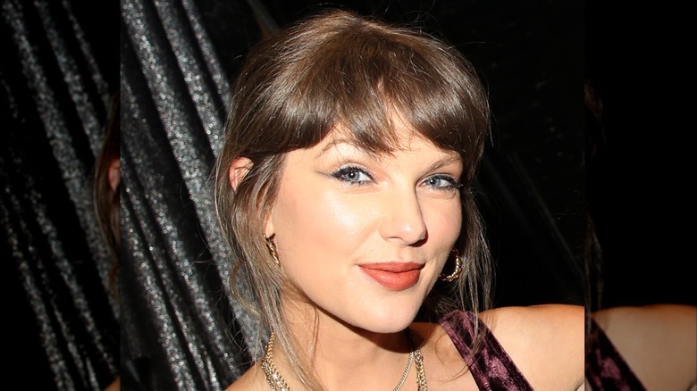 A close up of Taylor Swift in June 2026 wearing a purple tank top