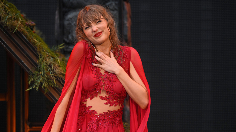 Taylor Swift on stage playing a moss-covered piano