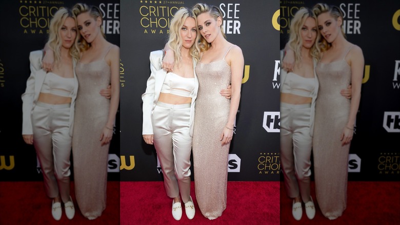 Kristen Stewart and Dylan Meyer posing with their heads close and an arm around one another while wearing light-colored outfits