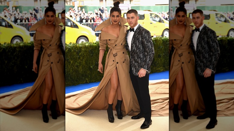 Priyanka Chopra and Nick Jonas posing with an arm around one another while looking off-camera with small smiles
