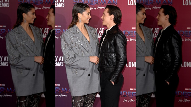 Zenday and Tom Holland smiling as they stand close to one another at a "Spider-Man" movie premiere