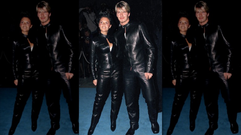 Victoria and David Beckham posing with arms around one another while wearing matching leather outfits