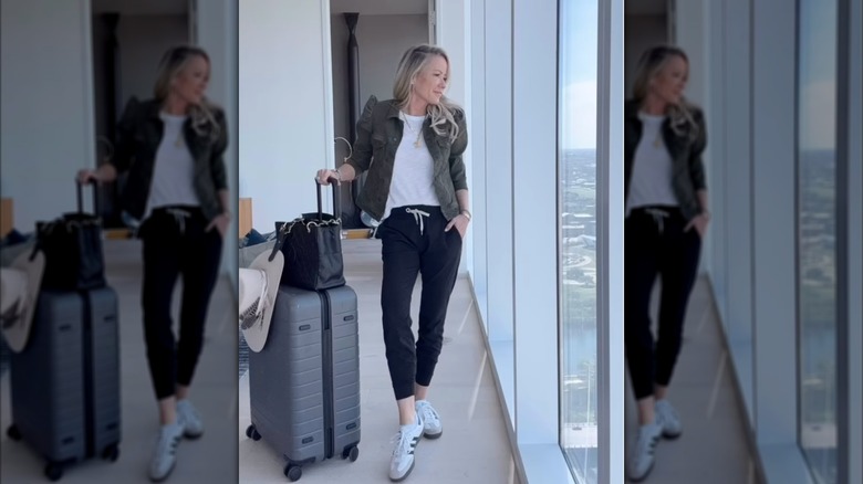 A woman in black joggers with a green jacket and sneakers
