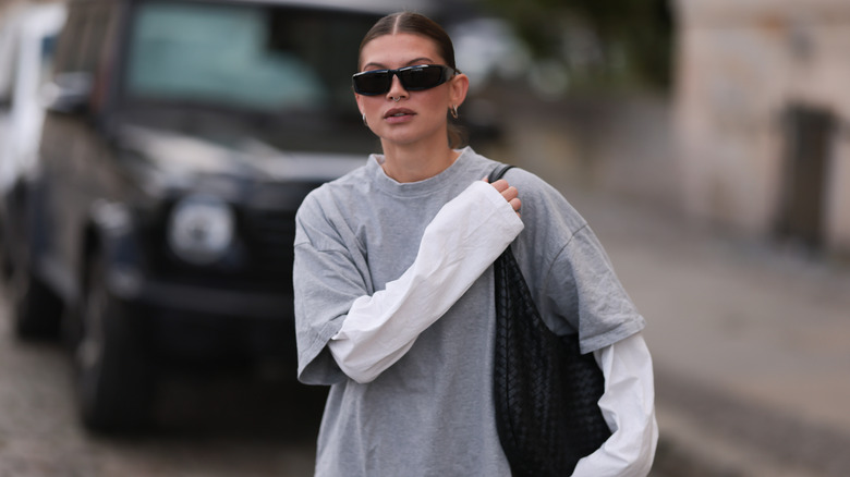 Woman wearing short-sleeved T-shirt over long-sleeved shirt
