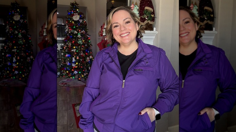 An influencer poses wearing a purple Members Only jacket