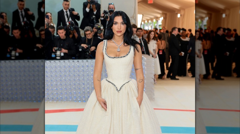 Dua Lipa wearing a white bridal gown and large diamond necklace
