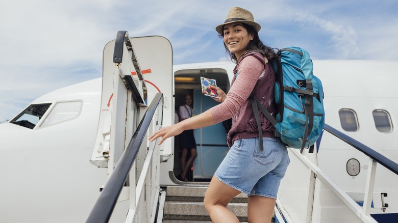 A woman with a backpack boarding a plane for a solo trip