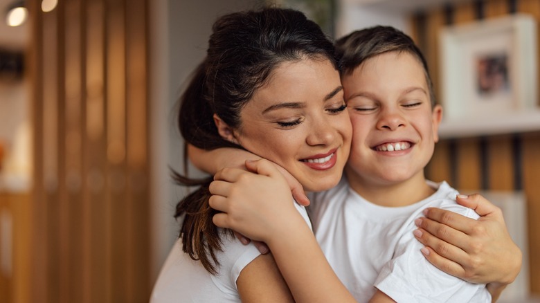 A woman and a younger boy sharing a hug