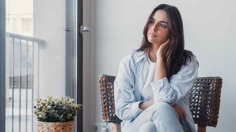 A woman sitting in a chair and looking upset