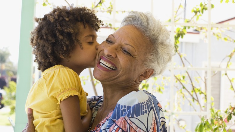 A little girl planting a kiss on her grandmother's cheek