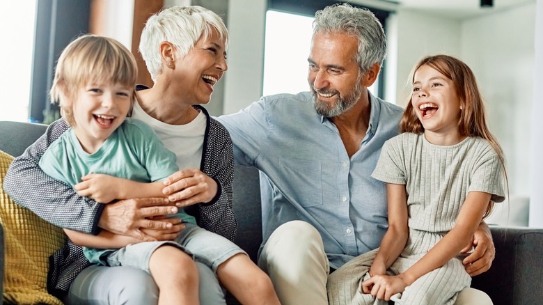 Two grandparents laughing with two of their grandchildren