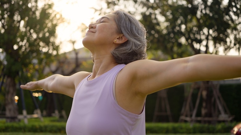 A woman standing outside with her arms outstretched