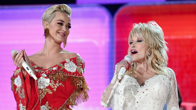 Katy Perry smiling at Dolly Parton while they perform on stage together