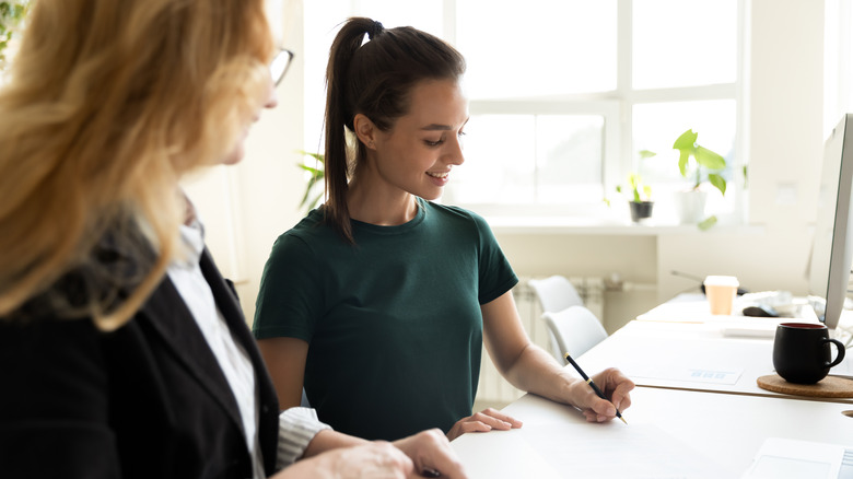 Women signing documents