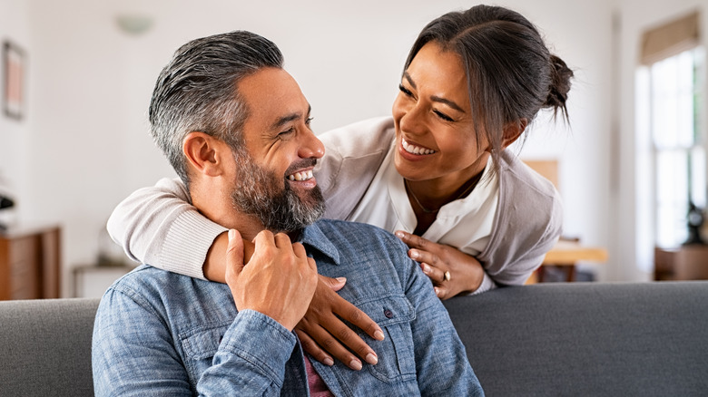 Woman hugging man & laughing