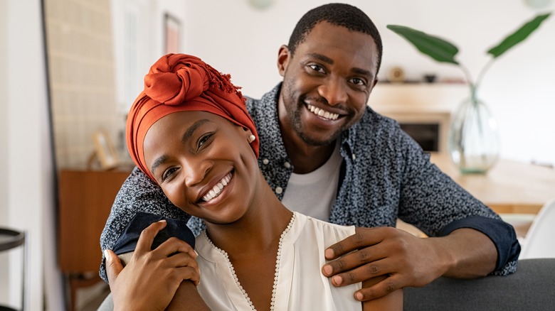 Couple embracing & smiling for camera