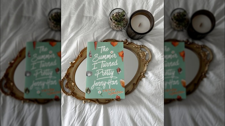 A copy of the novel "The Summer I Turned Pretty" on a tray on a bed