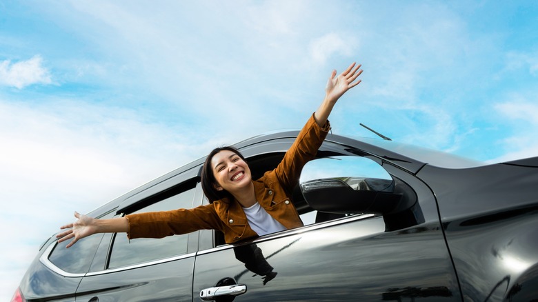 Woman leaning out of car window