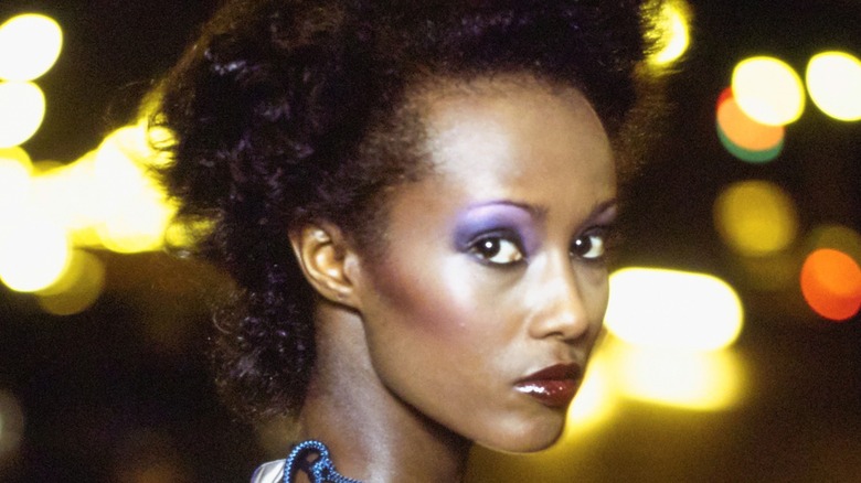 Iman with a neutral expression while wearing very vibrant makeup for a photoshoot for Vogue in 1974