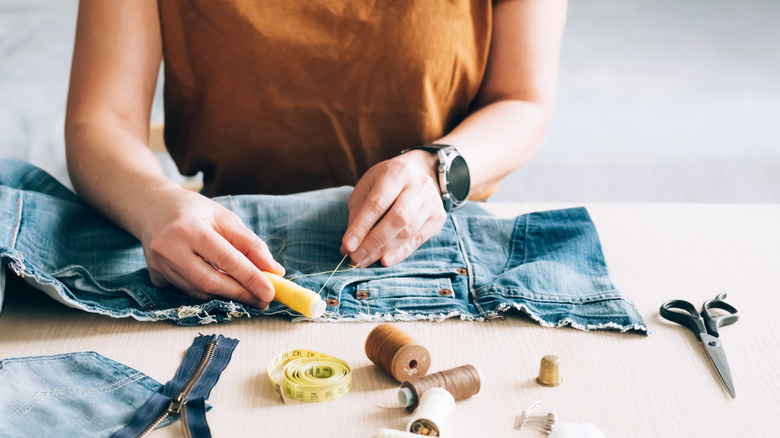 Woman sewing jeans