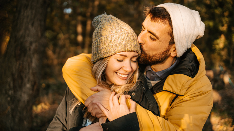 man kisses woman on cheek