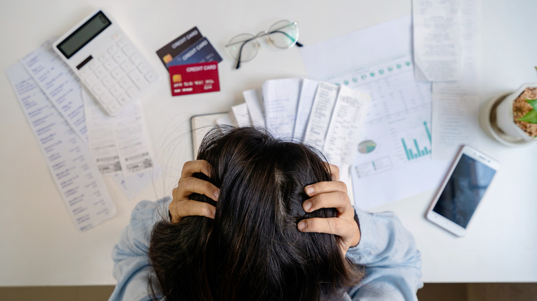 Woman with head in her hands and  table of bills