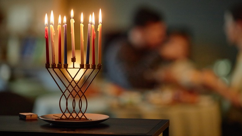 A family celebrating Hannukah with candles burning