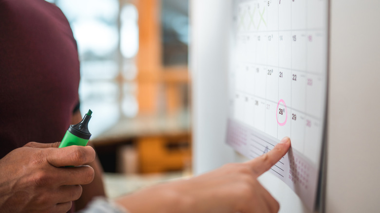 Person pointing to a calendar