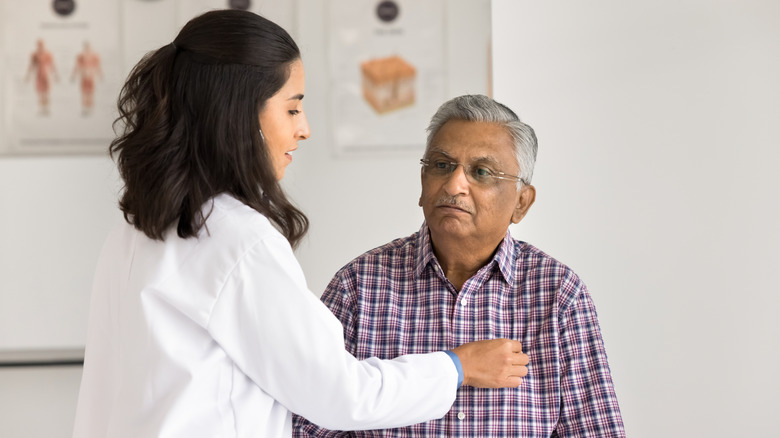 Doctor measuring a man's heartbeat