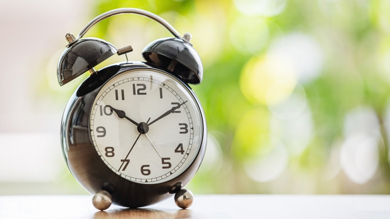 A black analogue alarm clock