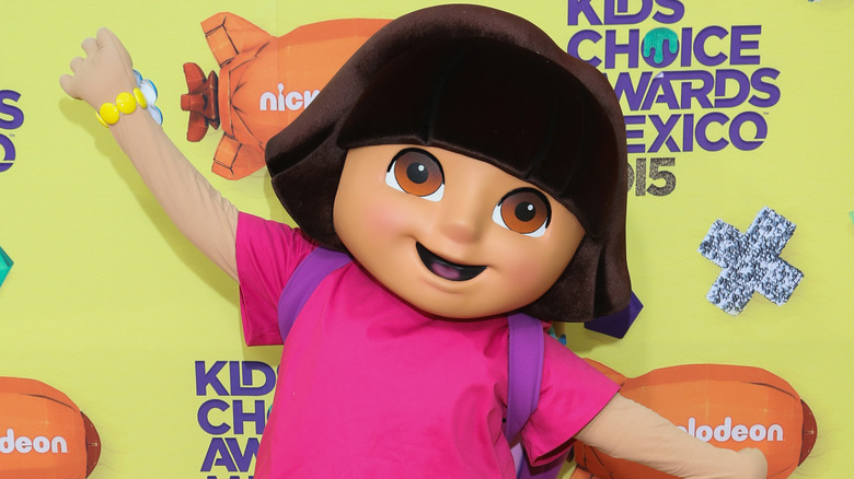A person waving while wearing a Dora the Explorer costume at an event in Italy
