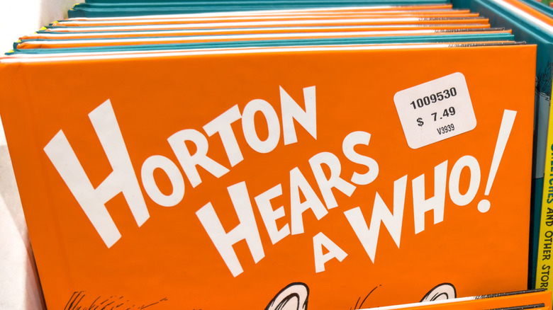 A hand holding the book Horton Hears a Who by Dr. Seuss