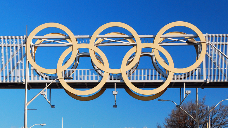 An Olympic flag flying in front of a blue sky
