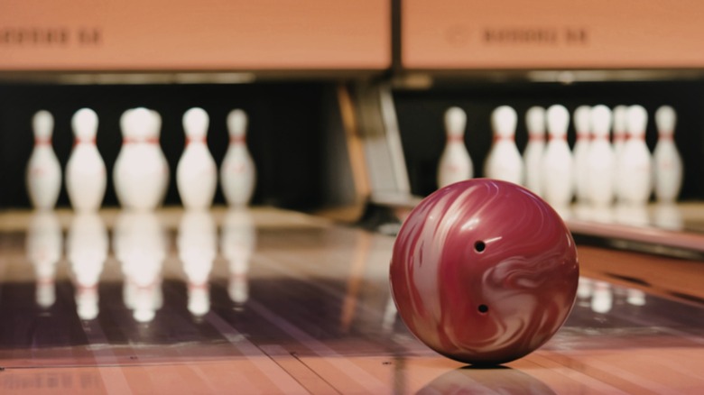 A bowling ball about to knock down pins