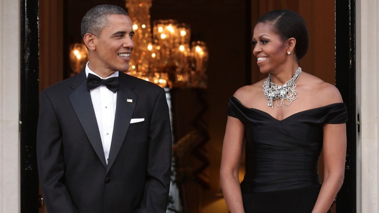 Barack Obama and Michelle Obama looking at one another while wearing formal attire